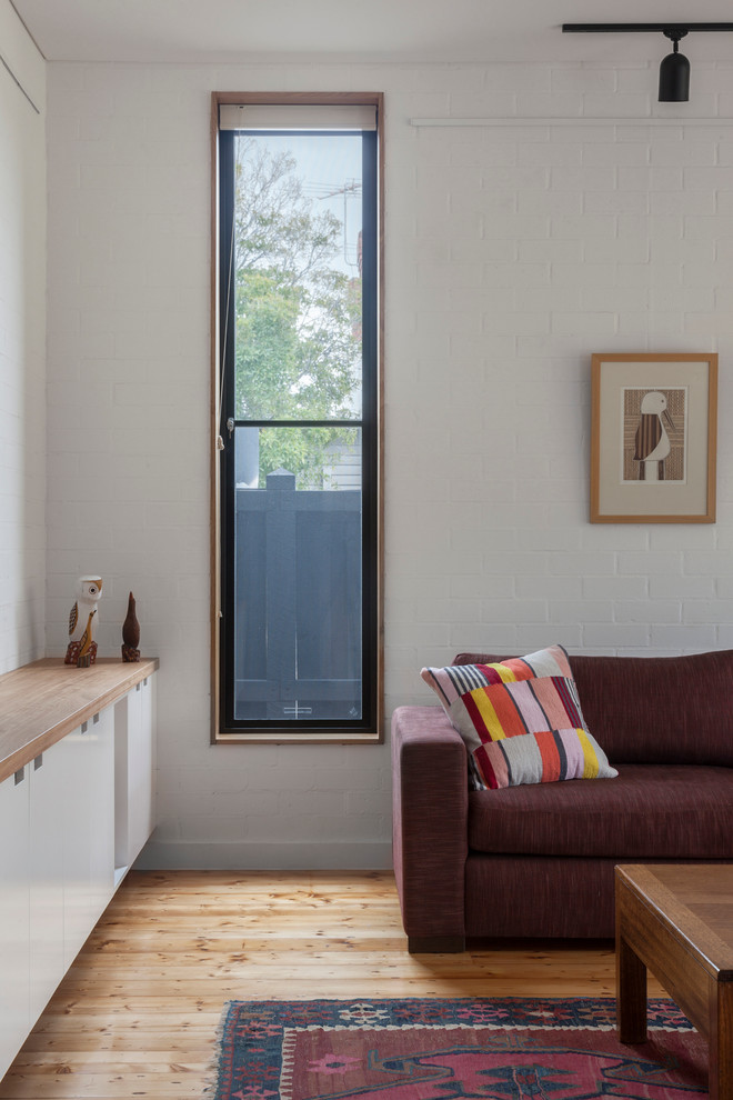 Mittelgroßes, Offenes Modernes Wohnzimmer mit weißer Wandfarbe und hellem Holzboden in Melbourne