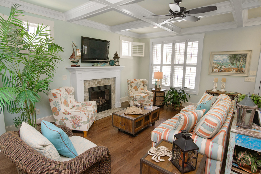 Mid-sized beach style medium tone wood floor living room photo in Other with blue walls, a standard fireplace, a tile fireplace and a wall-mounted tv