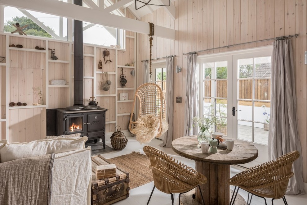 Ispirazione per un piccolo soggiorno rustico chiuso con pareti beige, stufa a legna e pavimento grigio