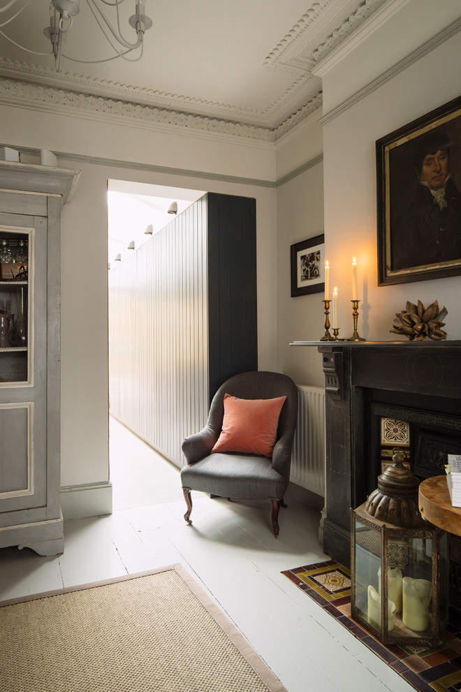 Exemple d'un salon chic avec un mur gris, parquet peint, une cheminée standard, un manteau de cheminée en bois et un sol blanc.
