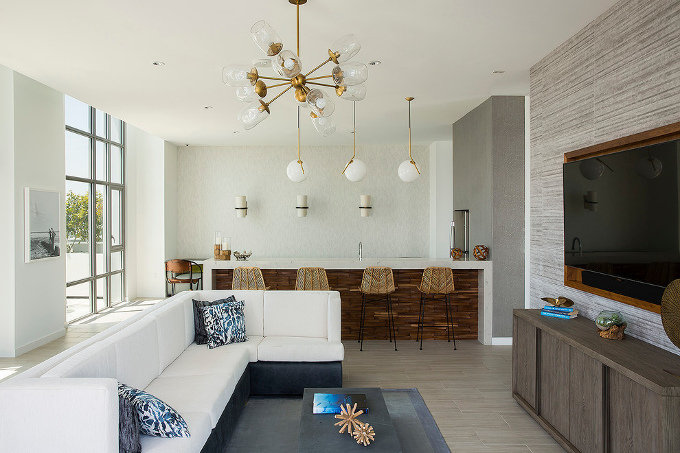 Идея дизайна: открытая гостиная комната в современном стиле с серыми стенами и телевизором на стене