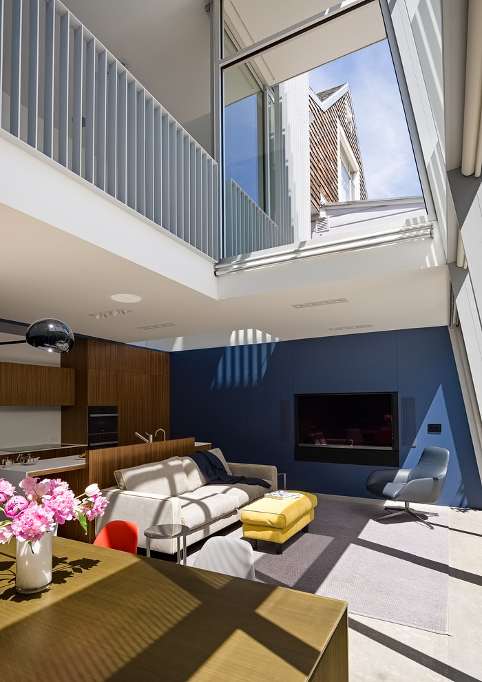 Idée de décoration pour un petit salon mansardé ou avec mezzanine minimaliste avec un mur bleu, un téléviseur encastré, un sol gris et un sol en linoléum.