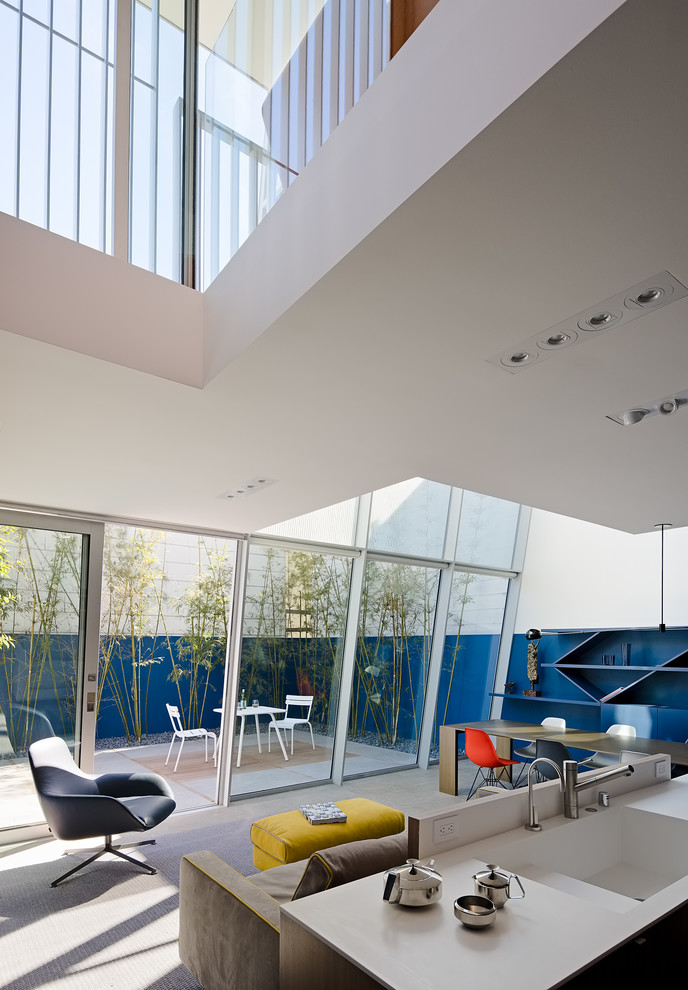 Diseño de salón tipo loft moderno pequeño con paredes azules, pared multimedia y suelo de piedra caliza