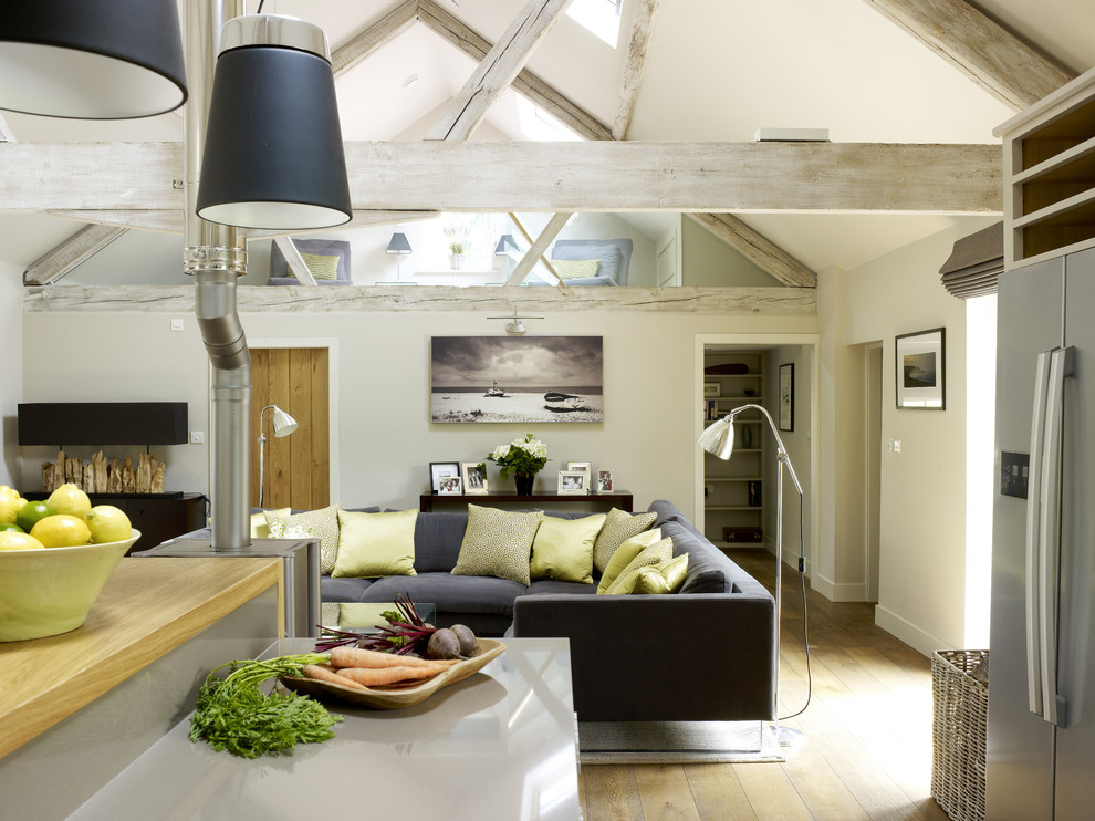 This is an example of a medium sized farmhouse open plan living room in London with grey walls, a two-sided fireplace and a wall mounted tv.