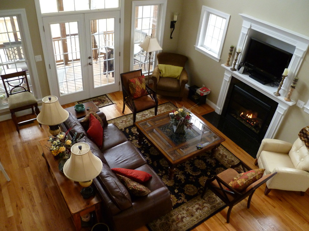 Photo of a medium sized traditional open plan living room in Charlotte with beige walls, medium hardwood flooring, a standard fireplace and a built-in media unit.