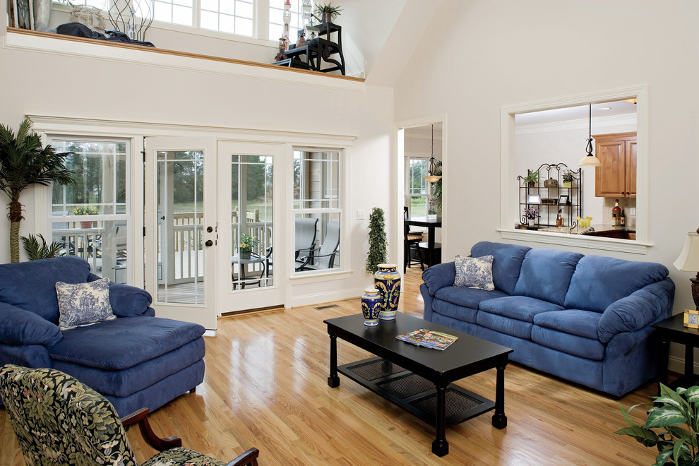 Photo of a medium sized classic open plan living room in Charlotte with white walls and light hardwood flooring.