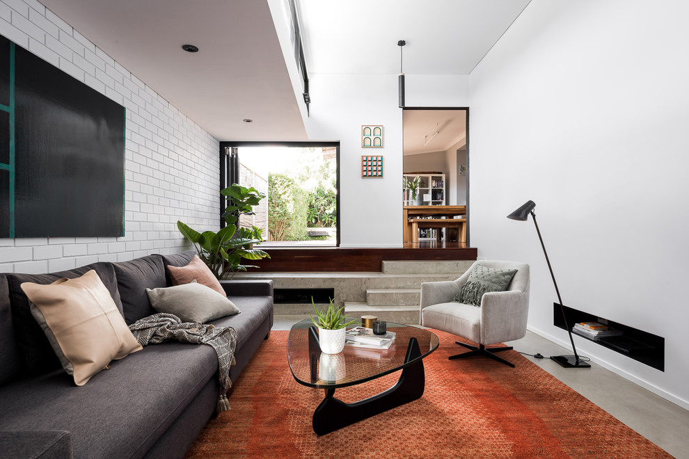 Inspiration pour un salon design avec un mur blanc, sol en béton ciré et un sol gris.