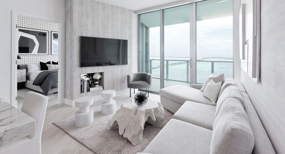 Contemporary living room in Miami with grey walls, a wall mounted tv and white floors.
