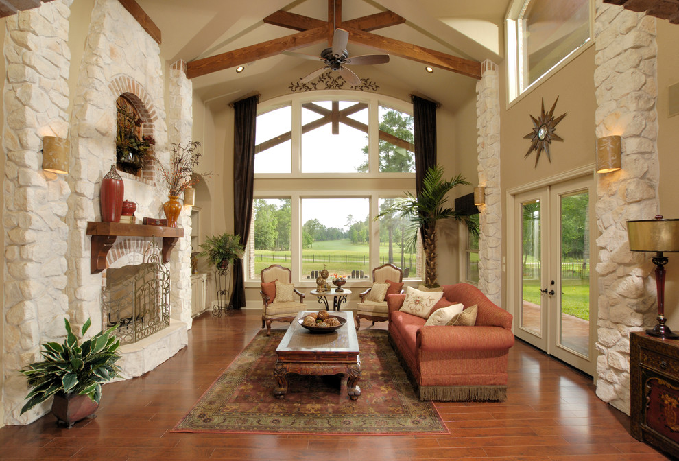Inspiration for a large timeless formal and enclosed medium tone wood floor and brown floor living room remodel in Houston with beige walls, a standard fireplace, a stone fireplace and no tv