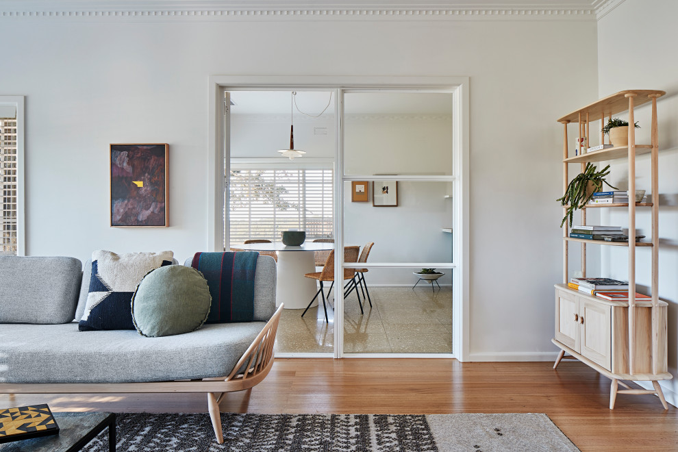 Foto di un soggiorno design chiuso con pareti bianche, pavimento in legno massello medio e pavimento marrone