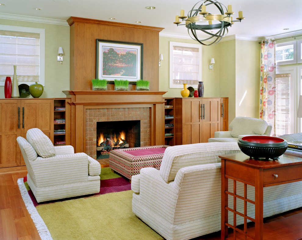 Photo of a contemporary living room in St Louis with green walls, a standard fireplace and a tiled fireplace surround.