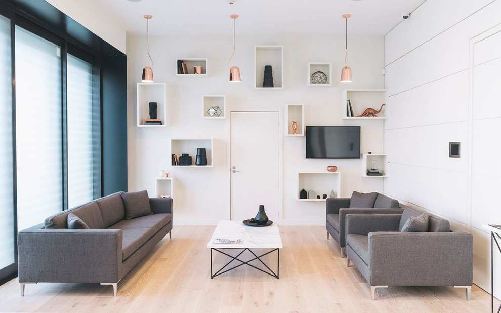 Свежая идея для дизайна: гостиная комната в скандинавском стиле с белыми стенами, светлым паркетным полом и телевизором на стене без камина - отличное фото интерьера