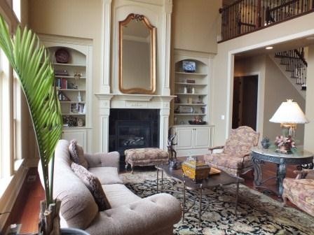 Exemple d'un grand salon chic ouvert avec une salle de réception, un mur beige, un sol en bois brun, une cheminée standard, un manteau de cheminée en bois et aucun téléviseur.