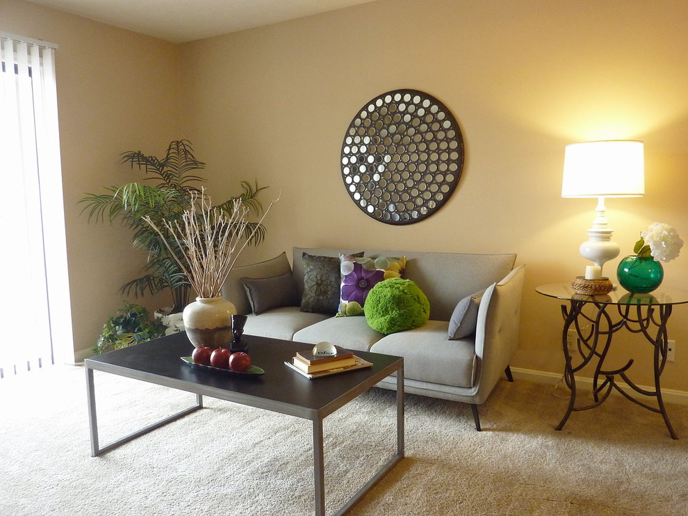 Immagine di un soggiorno minimal di medie dimensioni e aperto con pareti beige, moquette e pavimento beige