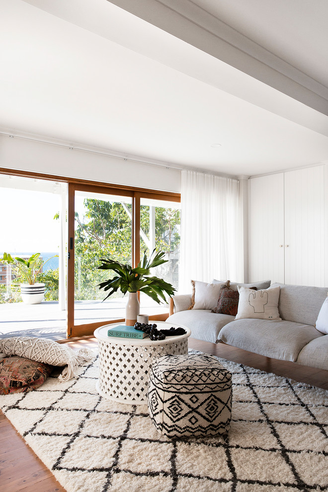 Ejemplo de salón abierto marinero con paredes blancas, suelo de madera en tonos medios y alfombra