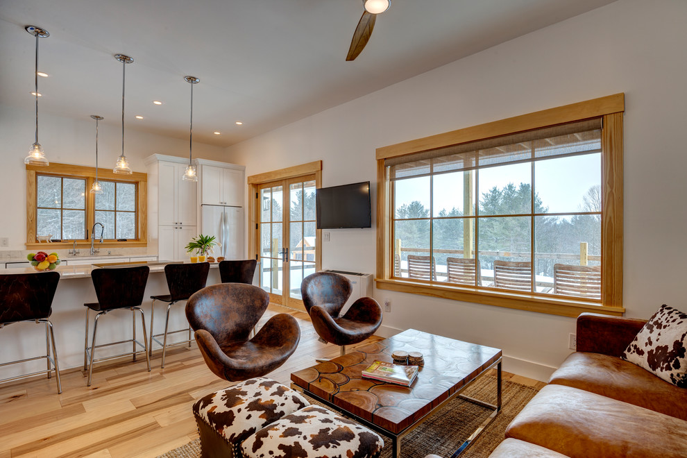 Diseño de salón abierto de estilo de casa de campo con paredes blancas, suelo de madera clara y suelo marrón