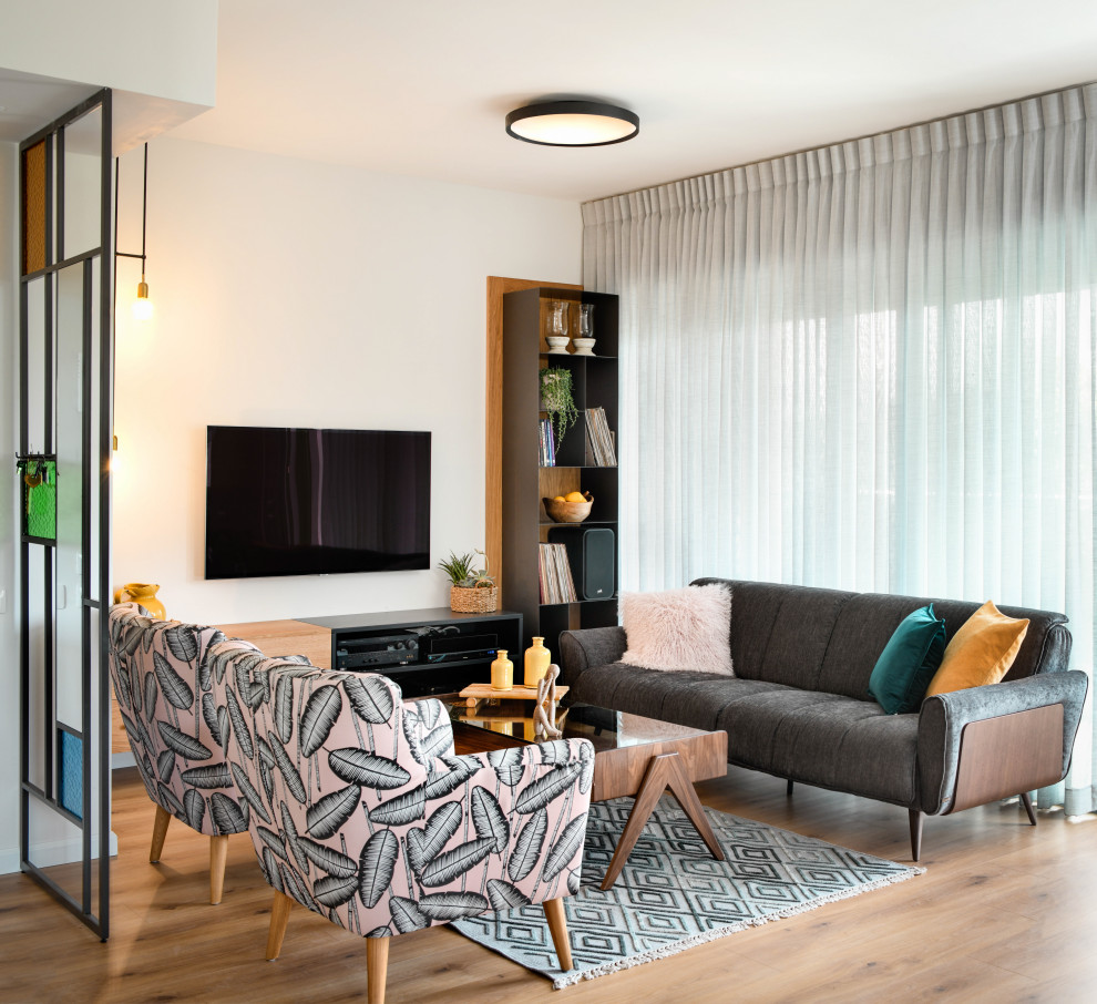 Cette image montre un salon design de taille moyenne et ouvert avec un mur blanc, un sol en bois brun, un téléviseur fixé au mur et un sol beige.