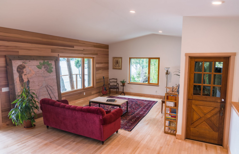 Imagen de salón abierto y abovedado tradicional renovado de tamaño medio sin chimenea y televisor con paredes blancas, suelo de madera clara y suelo marrón