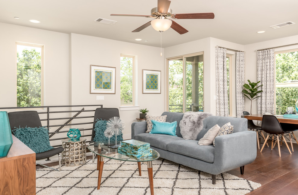Design ideas for a contemporary grey and teal mezzanine living room in Austin with grey walls and medium hardwood flooring.