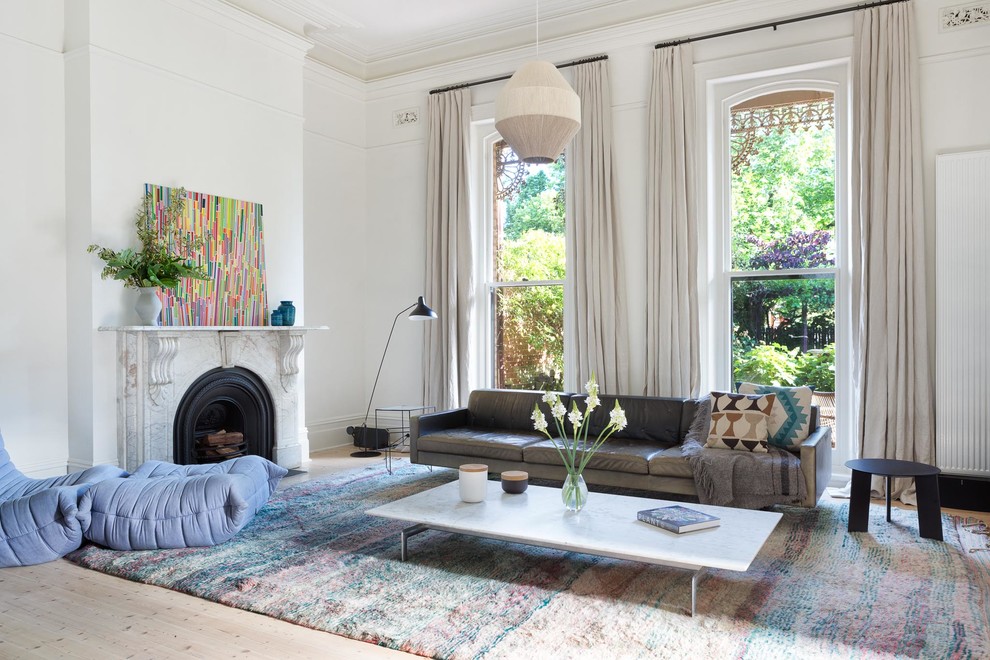 Immagine di un soggiorno chic con sala formale, pareti bianche, parquet chiaro, camino classico e pavimento beige