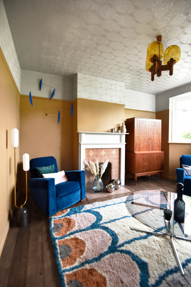 Ejemplo de salón cerrado vintage de tamaño medio con paredes marrones, todas las chimeneas, marco de chimenea de madera, televisor retractable y suelo marrón