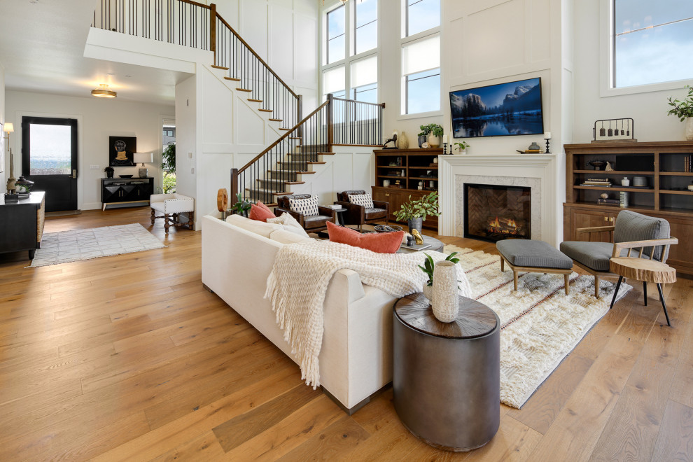 Offenes Klassisches Wohnzimmer mit weißer Wandfarbe, braunem Holzboden, Kamin, TV-Wand und braunem Boden in Portland