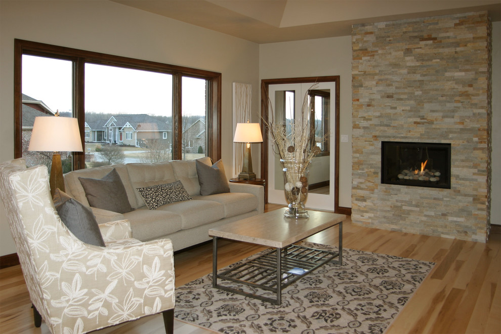 This is an example of a medium sized classic open plan living room in Other with beige walls, light hardwood flooring, a standard fireplace, a stone fireplace surround, no tv and beige floors.