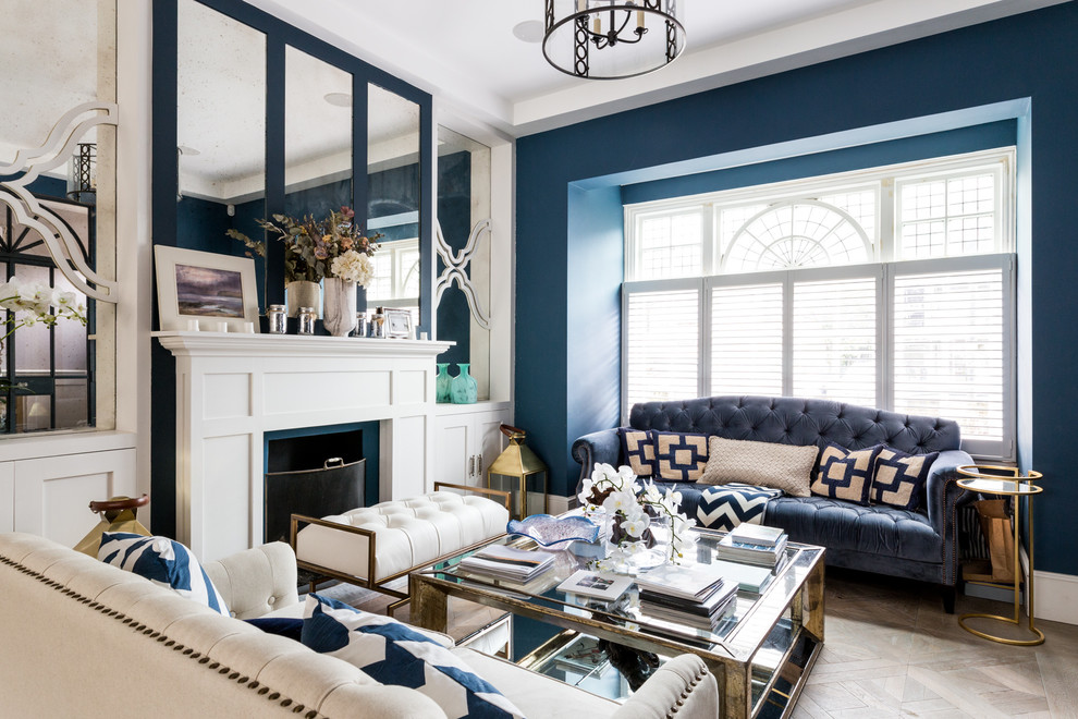 Стильный дизайн: парадная гостиная комната в стиле неоклассика (современная классика) с синими стенами, светлым паркетным полом, стандартным камином и бежевым полом - последний тренд