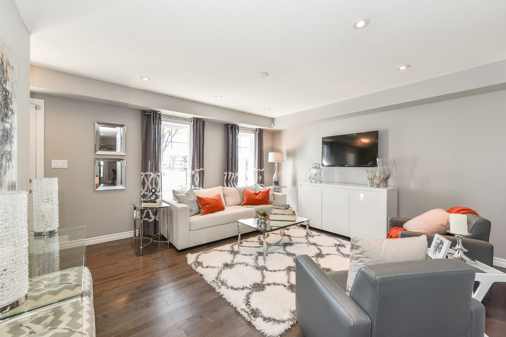 Mittelgroßes, Offenes Klassisches Wohnzimmer ohne Kamin mit grauer Wandfarbe, braunem Holzboden und TV-Wand in Toronto