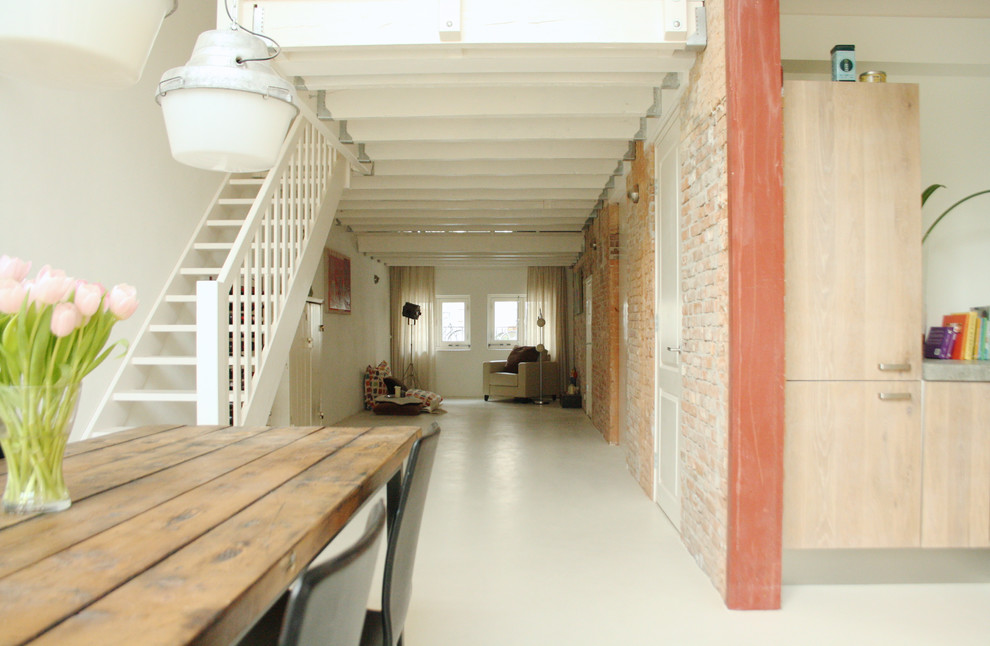Photo of a small industrial living room in Amsterdam with white floors.