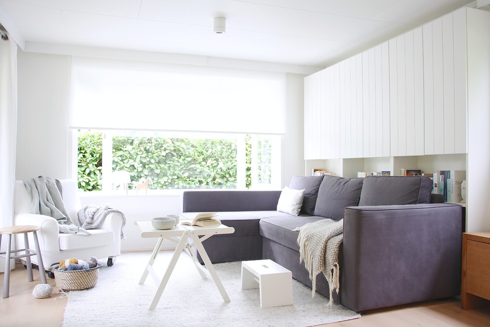 Example of a danish living room design in Amsterdam with white walls