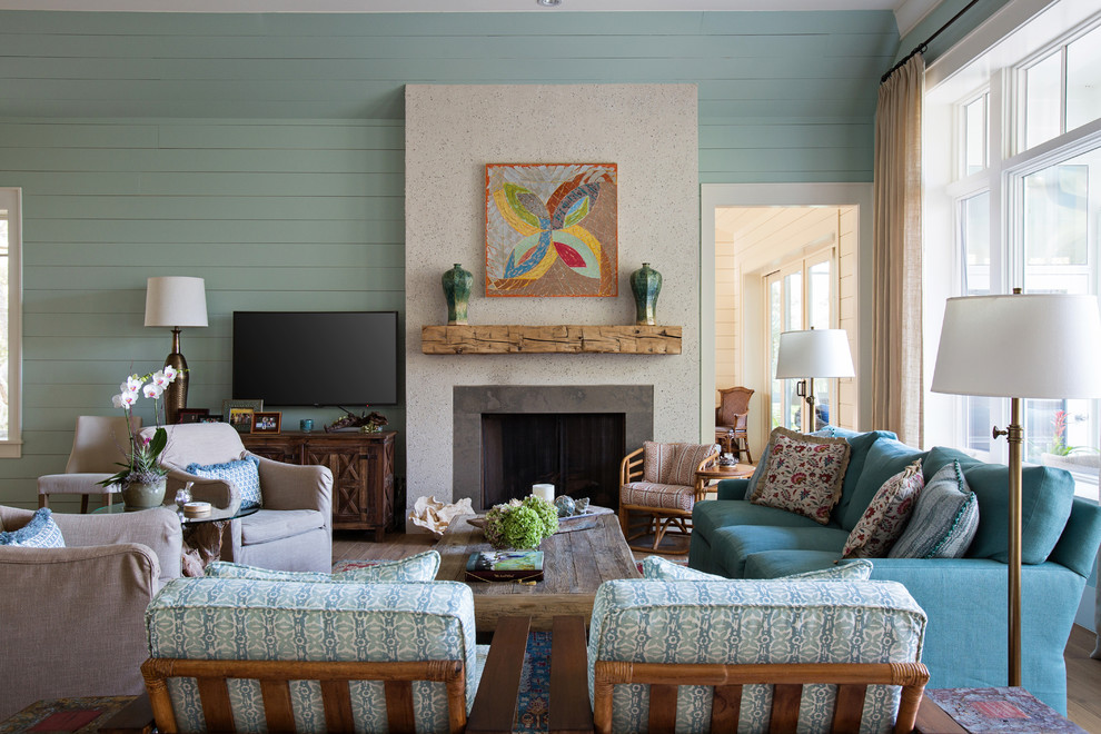 Cette photo montre un salon chic de taille moyenne et fermé avec un mur bleu, une cheminée standard, un manteau de cheminée en béton, un téléviseur fixé au mur et éclairage.