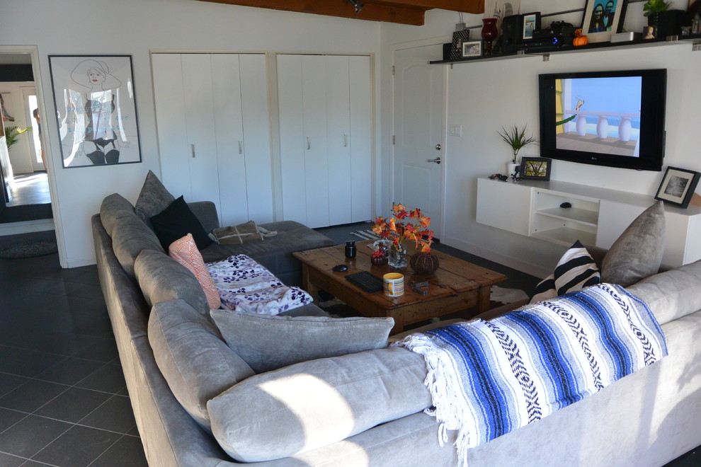 На фото: маленькая изолированная гостиная комната в стиле ретро с белыми стенами, полом из керамической плитки и скрытым телевизором для на участке и в саду