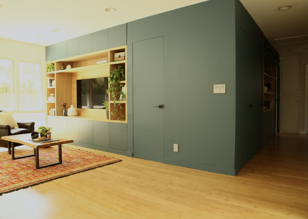 Immagine di un soggiorno minimalista di medie dimensioni e aperto con sala formale, pareti bianche, pavimento in bambù, parete attrezzata, nessun camino e pavimento marrone