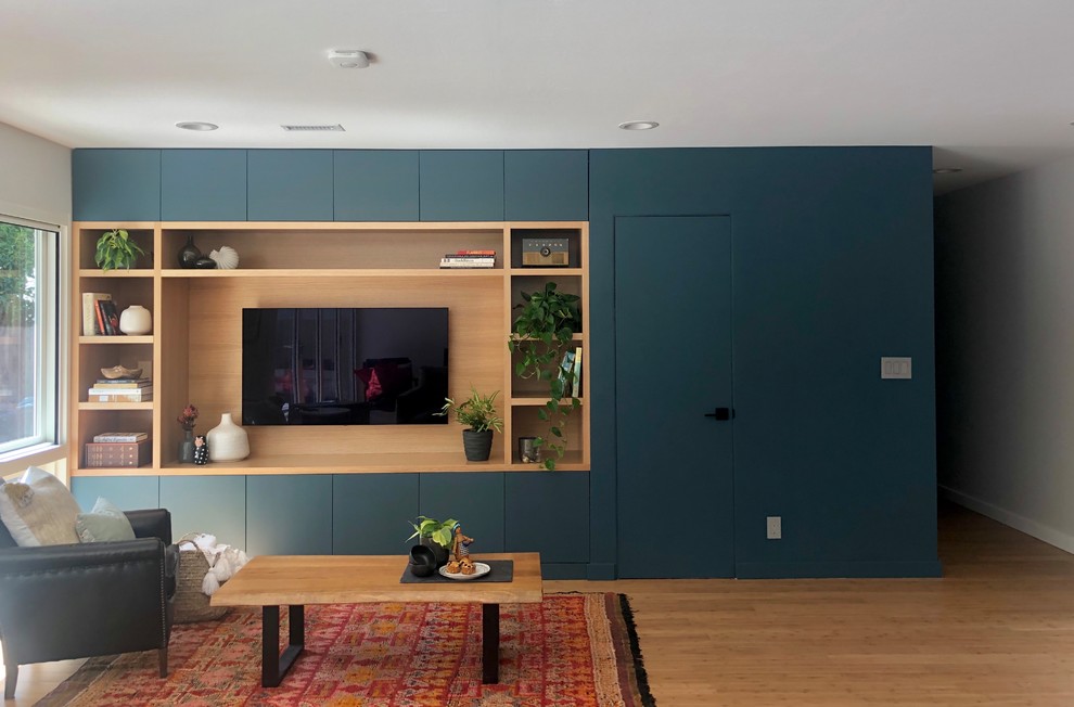 Immagine di un soggiorno minimalista di medie dimensioni e aperto con sala formale, pareti blu, pavimento in bambù, parete attrezzata, nessun camino e pavimento marrone