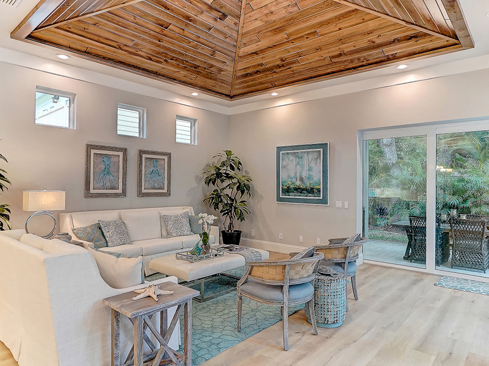 Large traditional open plan living room in Tampa with grey walls and light hardwood flooring.