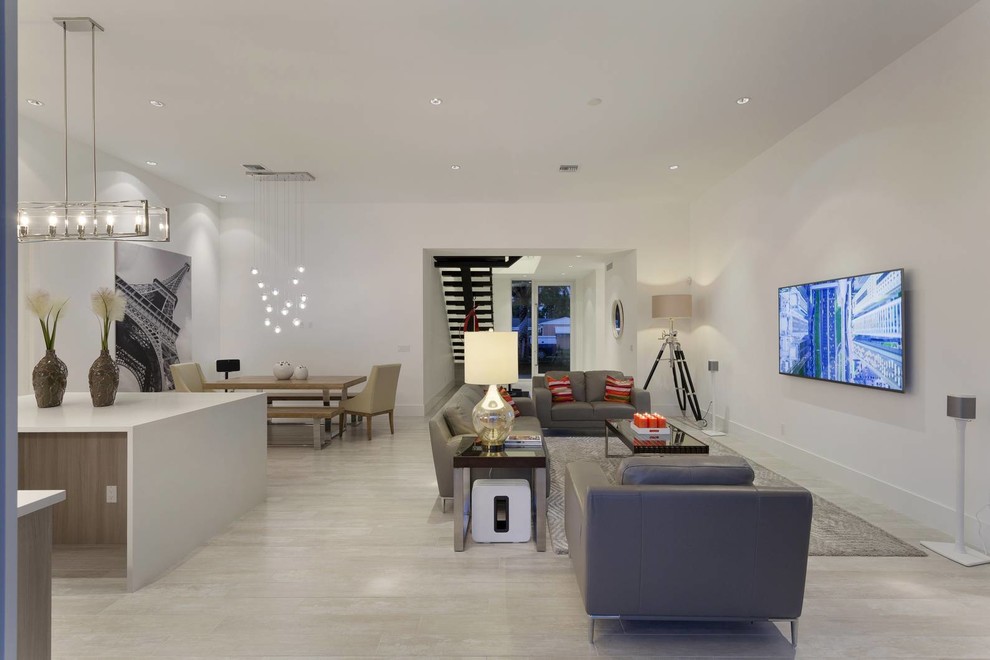 Immagine di un soggiorno minimalista di medie dimensioni e aperto con sala formale, pareti bianche, nessun camino, TV a parete e pavimento bianco