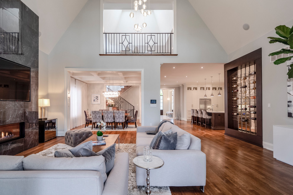 Offenes Klassisches Wohnzimmer mit grauer Wandfarbe, braunem Holzboden, gefliester Kaminumrandung, Multimediawand und braunem Boden in Toronto