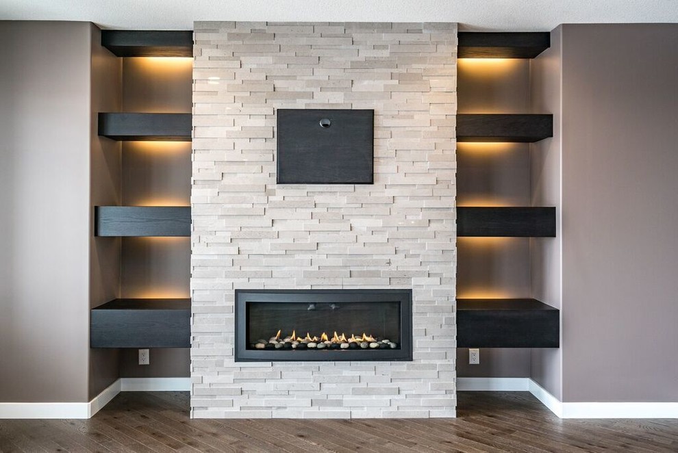 他の地域にある広いトラディショナルスタイルのおしゃれなLDK (茶色い壁、無垢フローリング、横長型暖炉、石材の暖炉まわり、壁掛け型テレビ、茶色い床) の写真