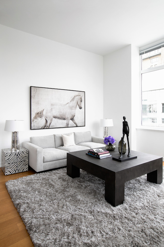 Idée de décoration pour un salon design de taille moyenne avec un mur blanc, un sol en bois brun et éclairage.