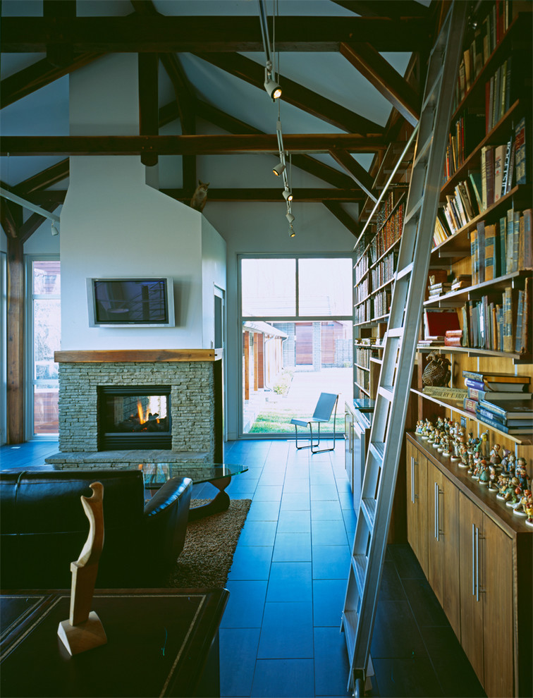 Источник вдохновения для домашнего уюта: гостиная комната в стиле модернизм с с книжными шкафами и полками и фасадом камина из камня