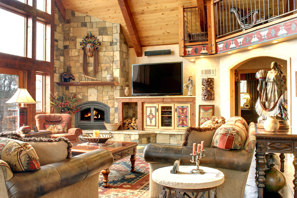 Living room - huge rustic open concept living room idea in Los Angeles with beige walls, a stone fireplace and a tv stand