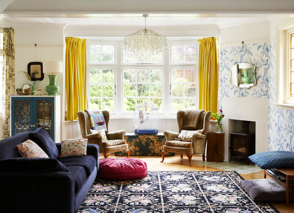 Stilmix Wohnzimmer mit weißer Wandfarbe, braunem Holzboden und Kaminofen in Sussex