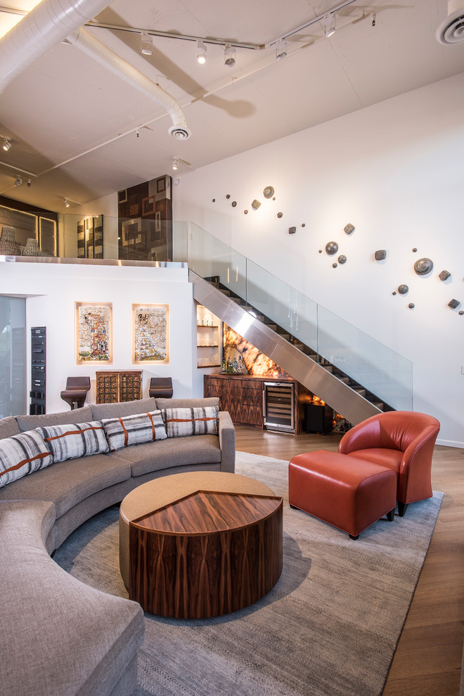 Imagen de salón abierto actual grande con suelo de madera en tonos medios, paredes blancas y suelo marrón