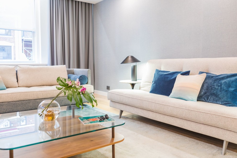 Idee per un soggiorno minimalista di medie dimensioni e aperto con sala formale, pareti blu, parquet chiaro, nessun camino, TV a parete e pavimento beige