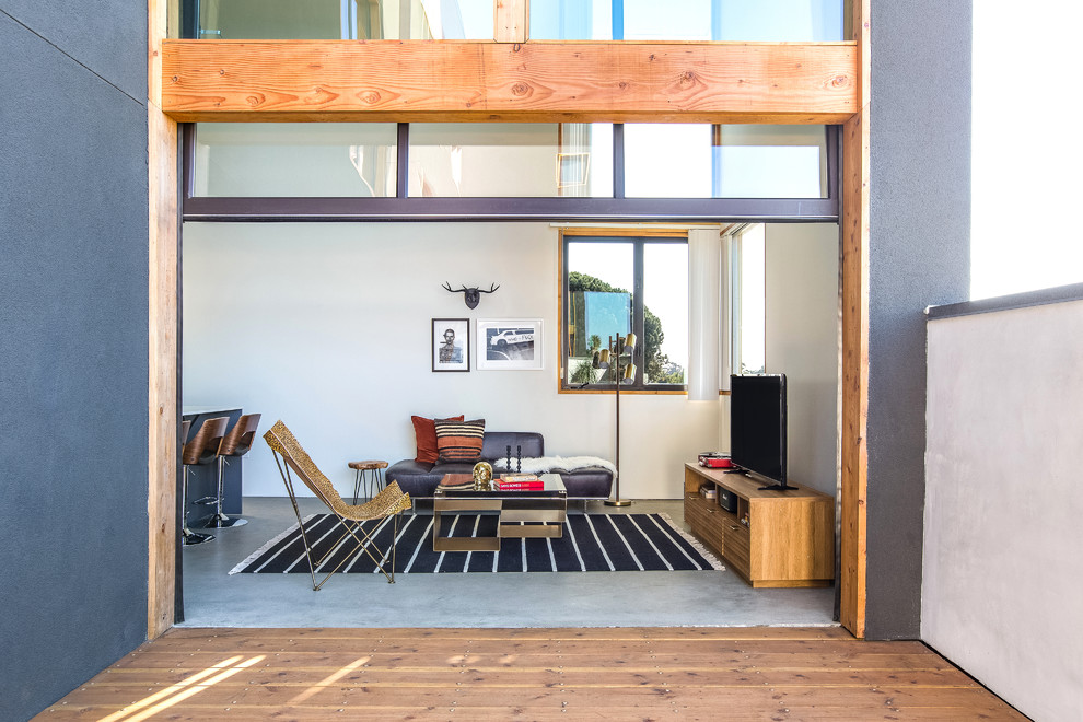 Foto di un soggiorno design aperto con pareti bianche, pavimento in cemento, TV autoportante e pavimento grigio