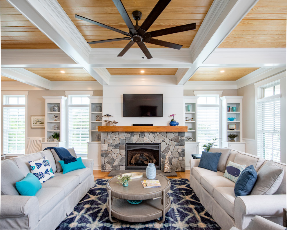 Photo of a nautical open plan living room in Other with grey walls, medium hardwood flooring, a standard fireplace, a stone fireplace surround, a wall mounted tv, brown floors, a coffered ceiling, a wood ceiling and wainscoting.