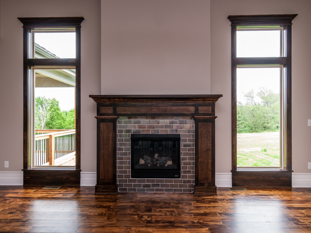 Inspiration for a large timeless open concept and formal dark wood floor living room remodel in Kansas City with a standard fireplace, a tile fireplace, beige walls and a wall-mounted tv