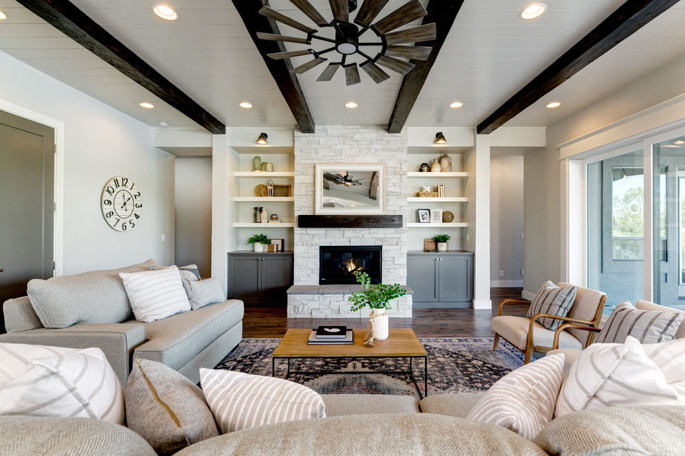 Repräsentatives, Fernseherloses Landhausstil Wohnzimmer mit grauer Wandfarbe, braunem Holzboden, Kamin, Kaminumrandung aus Backstein und braunem Boden in Boise