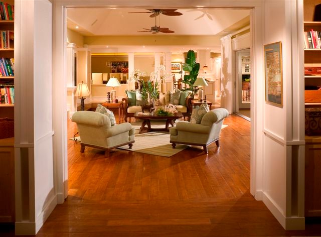 Immagine di un soggiorno stile marino aperto con pavimento in legno massello medio e TV nascosta